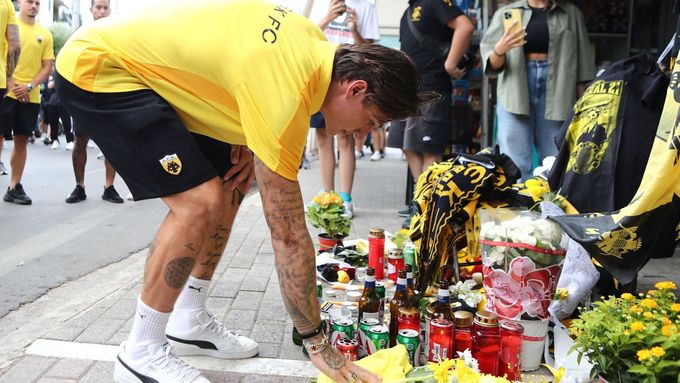 Fotbalista AEK Atény pokládá květiny u pietního místa na památku fanouška klubu, který byl ubodán při bitkách s příznivci Dinama Záhřeb