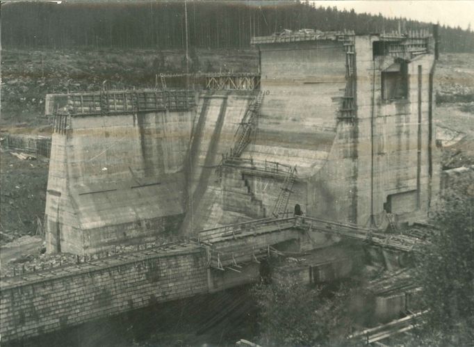 Fotografie ukazuje výstavbu vodní nádrže a elektrárny Lipno, významného díla z roku 1959, které dodává energii a poskytuje rekreační možnosti.