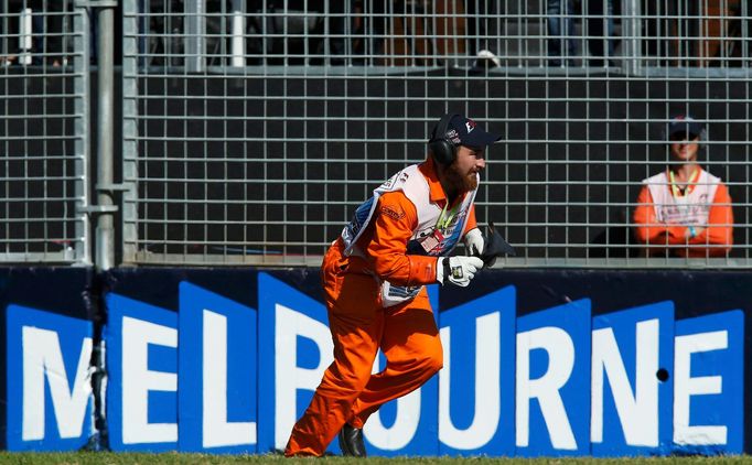 A race marshall picks up debris during the Australian F1 Grand Prix at the Albert Park circuit in Melbourne March 15, 2015. REUTERS/Brandon Malone (AUSTRALIA - Tags: SPOR