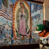 Man walks past a mural showing the Mexican, Salvadoran, Guatemalan and United States flags surrounding the Virgin of Guadalupe in the Westlake area of Los Angeles in California