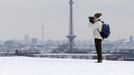 A man takes pictures of the snow covered skyline with the radio transmission tower (R) and the TV tower (L) in Berlin, March 12, 2013. REUTERS/Fabrizio Bensch (GERMANY - Tags: ENVIRONMENT) Published: Bře. 12, 2013, 12:12 odp.