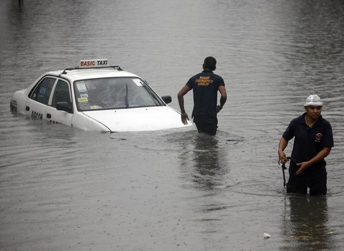 Members of a road emergency group tow a taxi stuck on a flooded street after a heavy downpour in Quezon City, Metro Manila July 3, 2012. Heavy rain has flooded some roads, causing classes to be suspended in parts of Metro Manila, local media reported. REUTERS/Cheryl Ravelo (PHILIPPINES - Tags: ENVIRONMENT TRANSPORT) Published: Čec. 3, 2012, 1:55 dop.