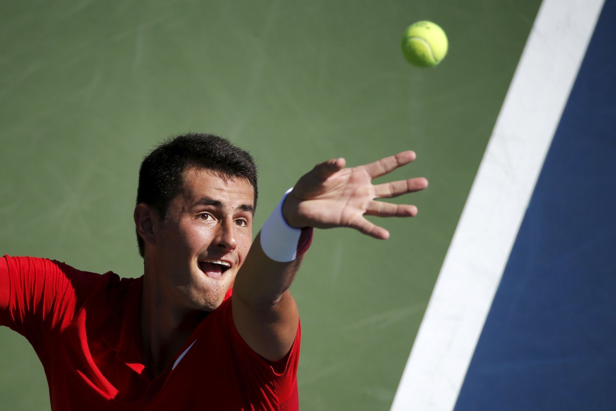 Tomic of Australia serves to Gasquet of France during their match at the U.S. Open Championships tennis tournament in New York