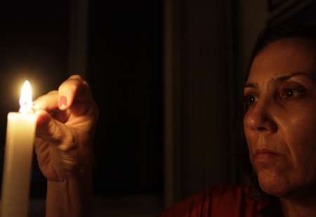 Žena zapaluje ve svém domě svíčku během výpadku elektřiny v Riu de Janeiru