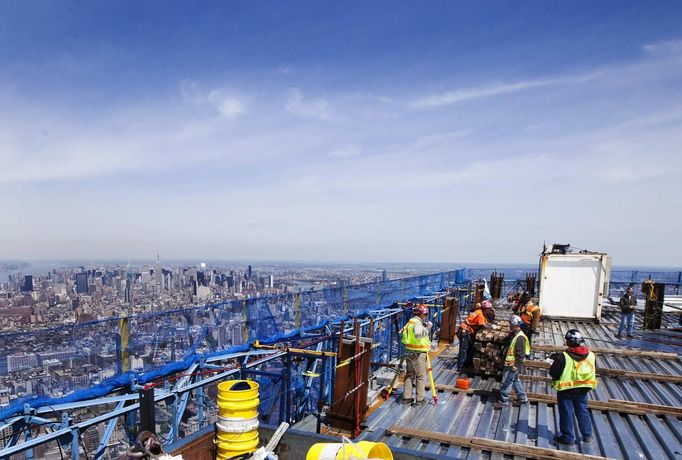 Iron workers walk around the steel decking on the 100th story of One World Trade Center in New York, April 30, 2012. The addition of iron columns to the 100th story pushed the height of One World Trade above that of the Empire State Building today. REUTERS/Lucas Jackson (UNITED STATES - Tags: TRANSPORT SCIENCE TECHNOLOGY) Published: Dub. 30, 2012, 11:40 odp.