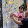 Woman writes her New Year wishes on a wishing wall display at a mall in Quezon city