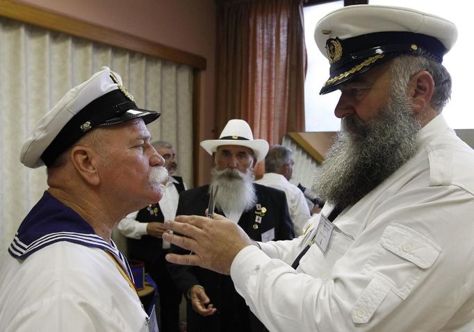 Participants help each other to get ready for the 2012 European Beard and Moustache Championships in Wittersdorf near Mulhouse, Eastern France, September 22, 2012. More than a hundred participants competed in the first European Beard and Moustache Championships organized in France. REUTERS/Vincent Kessler (FRANCE - Tags: SOCIETY) Published: Zář. 22, 2012, 7:28 odp.