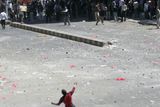 Provládní demonstrant hází kameny na protivládní demonstranty během únorových střetů v jemenském hlavním městě Saná.