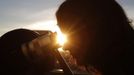 A woman looks through a telescope as the planet Venus transits across the sun during sunrise in Vienna, June 6, 2012. Venus made a slow transit across the face of the sun on Wednesday, the last such passing that will be visible from Earth for 105 years. REUTERS/Lisi Niesner (AUSTRIA - Tags: ENVIRONMENT SCIENCE TECHNOLOGY) Published: Čer. 6, 2012, 4:52 dop.