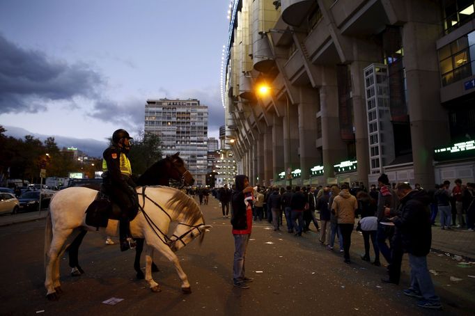 A soccer fan has his photo taken with mounted Spanish National Police officers as they queue to enter the Santiago Bernabeu stadium before the &quot;Clasico&quot; soccer