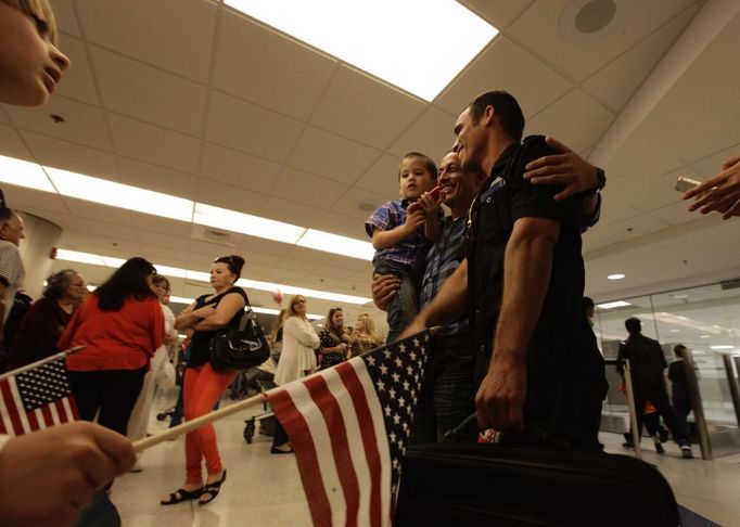 Luis Salgado (R), nicknamed Chucho, is reunited after ten years with his father, Jesus Salgado (C), and his half brother Kevin, after Luis arrived from Havana at Miami airport, March 13, 2013. Chucho was granted a U.S. visa based on his father's status as legal resident in Texas, and he was reunited in Miami with his father, who had escaped Cuba on a frail boat ten years earlier. The Salgados are among many Cubans taking advantage of Cuba's new travel policy in place since last January, which allows citizens to leave the country with just a passport and no need for much-hated exit visas required since 1961. Picture taken March 13, 2013. REUTERS/Desmond Boylan (UNITED STATES - Tags: POLITICS SOCIETY) Published: Dub. 11, 2013, 1:30 odp.