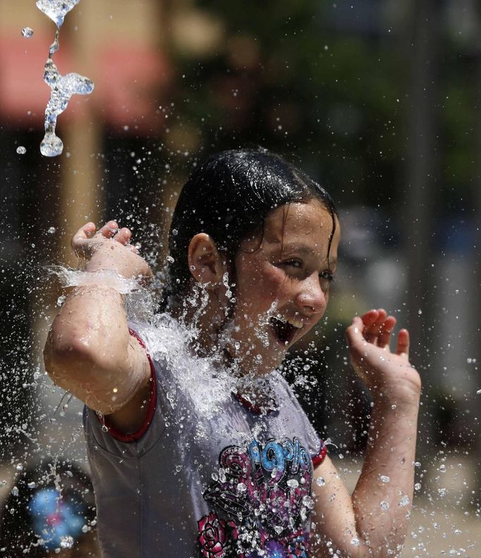 Gesel Ramos, 11 years old, of Silver Spring, Maryland, plays in a water fountain to beat the heat gripping the nation's capital while in the Capital Heights neighborhood of Washington, July 2, 2012. REUTERS/Larry Downing (UNITED STATES - Tags: SOCIETY ENVIRONMENT) Published: Čec. 2, 2012, 8:13 odp.