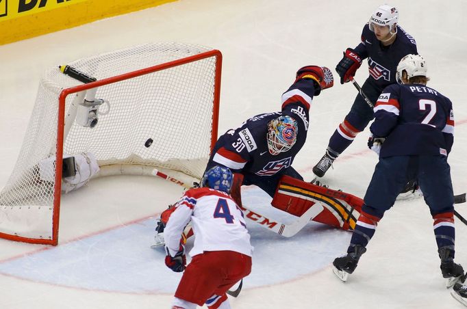 Goalie Tim Thomas of the U.S. (C) saves a shot from Jan Kovar of the Czech Republic (L) during their men's ice hockey World Championship quarter-final game at Chizhovka A