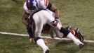 Justin Tuck skládá k zemi Toma Bradyho