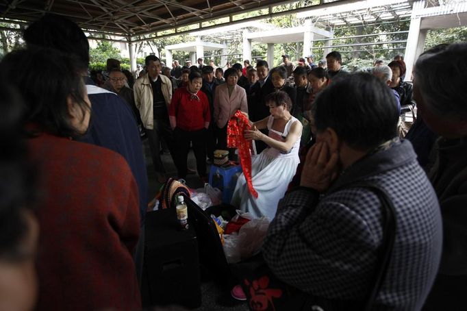 Xiao Cao, a 57-year-old gay man, changes his costume between performances at Manxi park in Shanghai April 8, 2012. China's gay community has long been on the edges of society but it is gradually becoming more accepted. Cao, who is an unemployed drag queen, is one whose life lifts the curtain on a less romanticised view of Chinese homosexuals. Living in an eight-square-metre apartment behind a public toilet and with a monthly income of 500 yuan ($79) from social insurance, he passes his days dancing in public and spending time with friends at gay clubs. Picture taken April 8, 2012. REUTERS/Aly Song (CHINA - Tags: SOCIETY) CHINA OUT. NO COMMERCIAL OR EDITORIAL SALES IN CHINA. ATTENTION EDITORS PICTURE 15 OF 28 OF PACKAGE 'GAY AND OUT IN CHINA' TO FIND ALL IMAGES SEARCH 'GAY OUT CHINA' Published: Čer. 1, 2012, 12:38 dop.