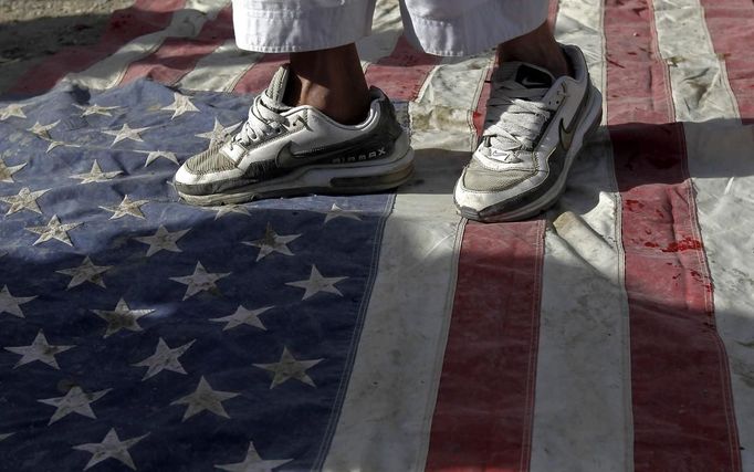 An Afghan protester steps on a U.S. flag during a demonstration in Kabul, September 21, 2012. Hundreds of Afghans protested against a U.S.-made film they say insults the Prophet Mohammad. REUTERS/Omar Sobhani (AFGHANISTAN - Tags: RELIGION) Published: Zář. 21, 2012, 12:36 odp.