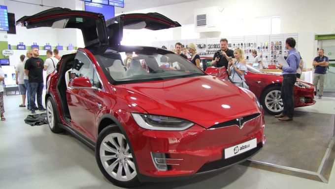 Tesla model X v popředí v showroomu Alzy