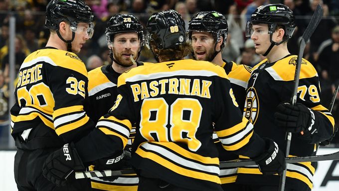 David Pastrňák oslavuje se spoluhráči z Bostonu gól v síti Chicaga.