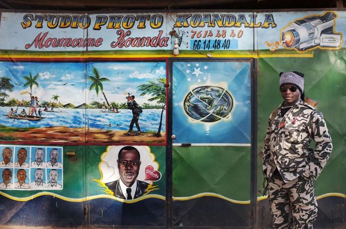 Malian soldier Aliou Doumbe poses for a picture next to a photo studio in Niono January 20, 2013. France and West African leaders called on Saturday on other world powers to commit money and logistical support for African armies readying their troops to join French soldiers already battling al Qaeda-linked militants in Mali. REUTERS/Joe Penney (MALI - Tags: CIVIL UNREST POLITICS MILITARY CONFLICT) Published: Led. 20, 2013, 10:31 dop.