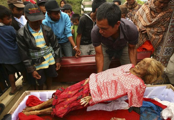 A man removes a mummy from a coffin before giving it new clothes in a ritual in the Toraja district of Indonesia's South Sulawesi Province, August 23, 2012. The ritual, called Ma'nene, involves changing the clothes every three years of mummified ancestors to honor love for the deceased. Locals believe dead family members are still with them, even if they died hundreds of years ago, a family spokesman said. Picture taken August 23, 2012. REUTERS/Yusuf Ahmad (INDONESIA - Tags: SOCIETY RELIGION) Published: Srp. 24, 2012, 1:03 odp.