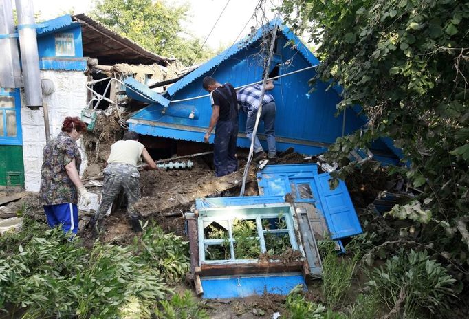 Local residents work amidst the debris of a house, damaged by floods, in the town of Krymsk in Krasnodar region, southern Russia, July 8, 2012. Russian President Vladimir Putin ordered investigators to find out if enough was done to prevent 144 people being killed in floods in southern Russia after flying to the region to deal with the first big disaster of his new presidency. REUTERS/Eduard Korniyenko (RUSSIA - Tags: DISASTER ENVIRONMENT POLITICS) Published: Čec. 8, 2012, 7:57 dop.