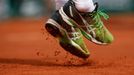 Marsel Ilhan of Turkey jumps to play a shot to Stan Wawrinka of Switzerland during their men's singles match at the French Open tennis tournament at the Roland Garros sta