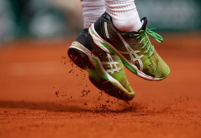 Marsel Ilhan of Turkey jumps to play a shot to Stan Wawrinka of Switzerland during their men's singles match at the French Open tennis tournament at the Roland Garros sta