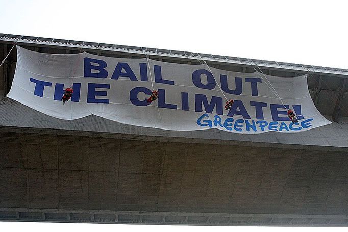 Horolezci z řad Greenpeace připevňují transparent na nuselský most.