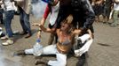 A supporter of a native Indian community living at the Brazilian Indian Museum is dragged by a military officer during a protest against the community's eviction in Rio de Janeiro, March 22, 2013. Brazilian military police took position early morning outside the abandoned museum, where the community of around 30 native Indians have been living in since 2006. The community was ordered to leave the museum in 72 hours by court officials since last week, local media reported. Most of the Indians later left the museum after making a deal with the authorities. REUTERS/Pilar Olivares (BRAZIL - Tags: POLITICS CIVIL UNREST SOCIETY) Published: Bře. 22, 2013, 7:04 odp.