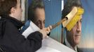 A UMP party activist glues election campaign posters in support of Sarkozy, France's President and UMP party candidate for the 2012 French presidential election, on an official board in Paris