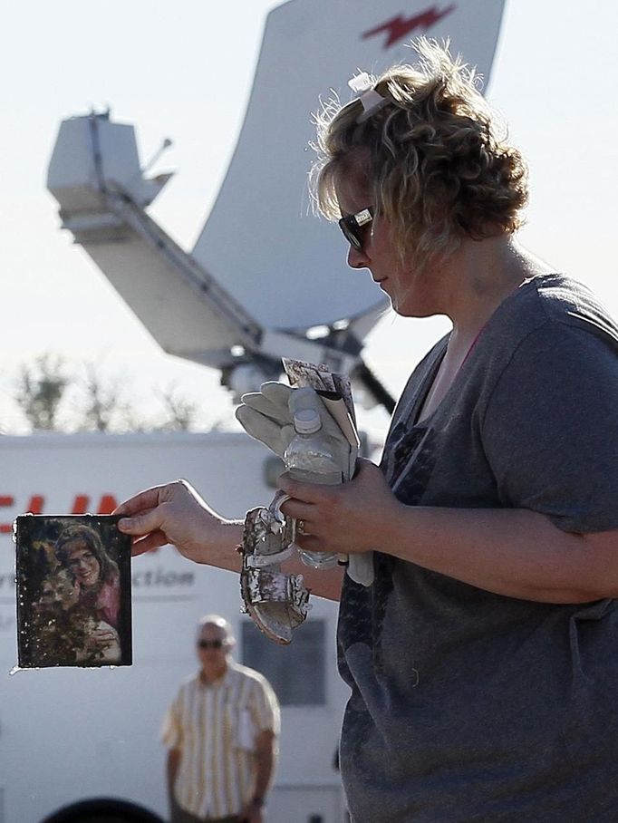 Water drips off a photo salavaged by a woman from her tornado-destroyed home in Moore, Oklahoma May 21, 2013. Rescuers went building to building in search of victims and thousands of survivors were homeless on Tuesday after a massive tornado tore through the Oklahoma City suburb of Moore, wiping out whole blocks of homes and killing at least 24 people. REUTERS/Rick Wilking (UNITED STATES - Tags: DISASTER ENVIRONMENT) Published: Kvě. 22, 2013, 1:57 dop.