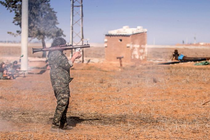 A female fighter of the Kurdish People's Protection Units (YPG) fires a Rocket-propelled grenade (RPG) as she participates in a military training