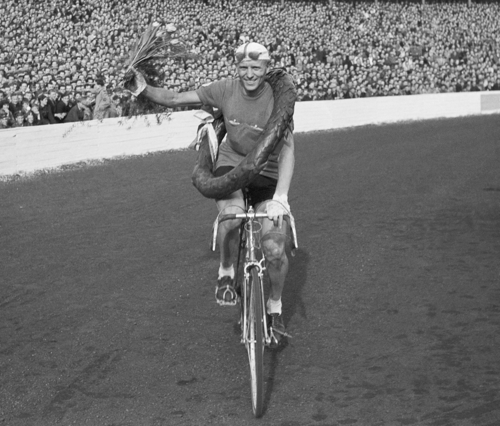 Vítěz X. etapy Závodu míru 1955 Jan Veselý jede čestné kolo na stadionu ve Vratislavi.