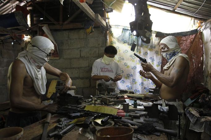 Filipino gunsmiths work in an illegal makeshift gun factory on the outskirts of Danao in central Philippines July 8, 2012. In the Philippines, they vote with their trigger fingers. Elections mean big business for illegal gunsmiths, who are looking forward to 2013 mid-term polls. With election-related violence commonplace, the Philippines imposes a ban on the carrying of guns for six months, from campaigning to the proclamation of winners. Picture taken July 8, 2012. To match Feature PHILIPPINES-GUNS/ REUTERS/Erik De Castro (PHILIPPINES - Tags: SOCIETY POLITICS BUSINESS CRIME LAW) Published: Čec. 29, 2012, 2:32 dop.