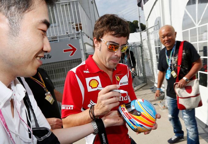 Španělský pilot F1 Fernando Alonso rozdává autogramy při kvalifikaci na VC Japonska 2012 v Suzuce.