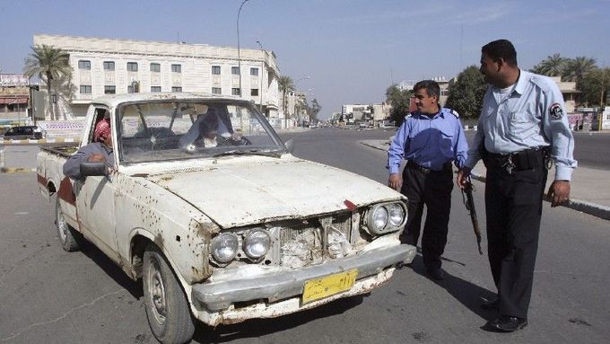 Irácký policista zastavuje auto v centru Bagdádu.