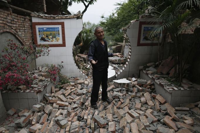 Wang Zhenjun, 62, gestures as he speaks to journalists in front of his damaged house after Saturday's earthquake in Lushan county, April 22, 2013. Rescuers struggled to reach a remote, rural corner of southwestern China on Sunday as the toll of the dead and missing from the country's worst earthquake in three years climbed to 208 with almost 1,000 serious injuries. The 6.6 magnitude quake struck in Lushan county, near the city of Ya'an in the southwestern province of Sichuan, close to where a devastating 7.9 quake hit in May 2008, killing 70,000. REUTERS/Aly Song (CHINA - Tags: DISASTER SOCIETY) Published: Dub. 22, 2013, 3:43 dop.