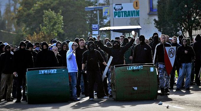 Zpoza převrácených kontejnerů provokovali radikálové policejní těžkooděnce.