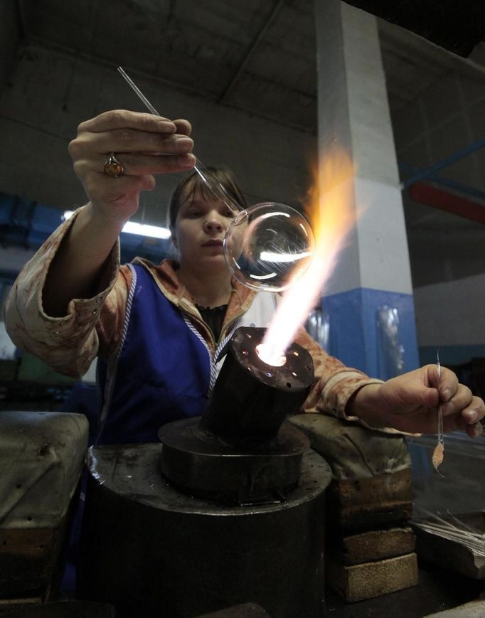 An employee works on a glass sphere for Christmas and New Year decorations, at the "Biryusinka" toys factory in Russia's Siberian city of Krasnoyarsk November 27, 2012. The factory, founded in 1942, produces decorative glass spheres, which can be found on Christmas trees all over the country and in Moscow's Kremlin in particular, during the festive season. REUTERS/Ilya Naymushin (RUSSIA - Tags: SOCIETY) Published: Lis. 27, 2012, 3:52 odp.