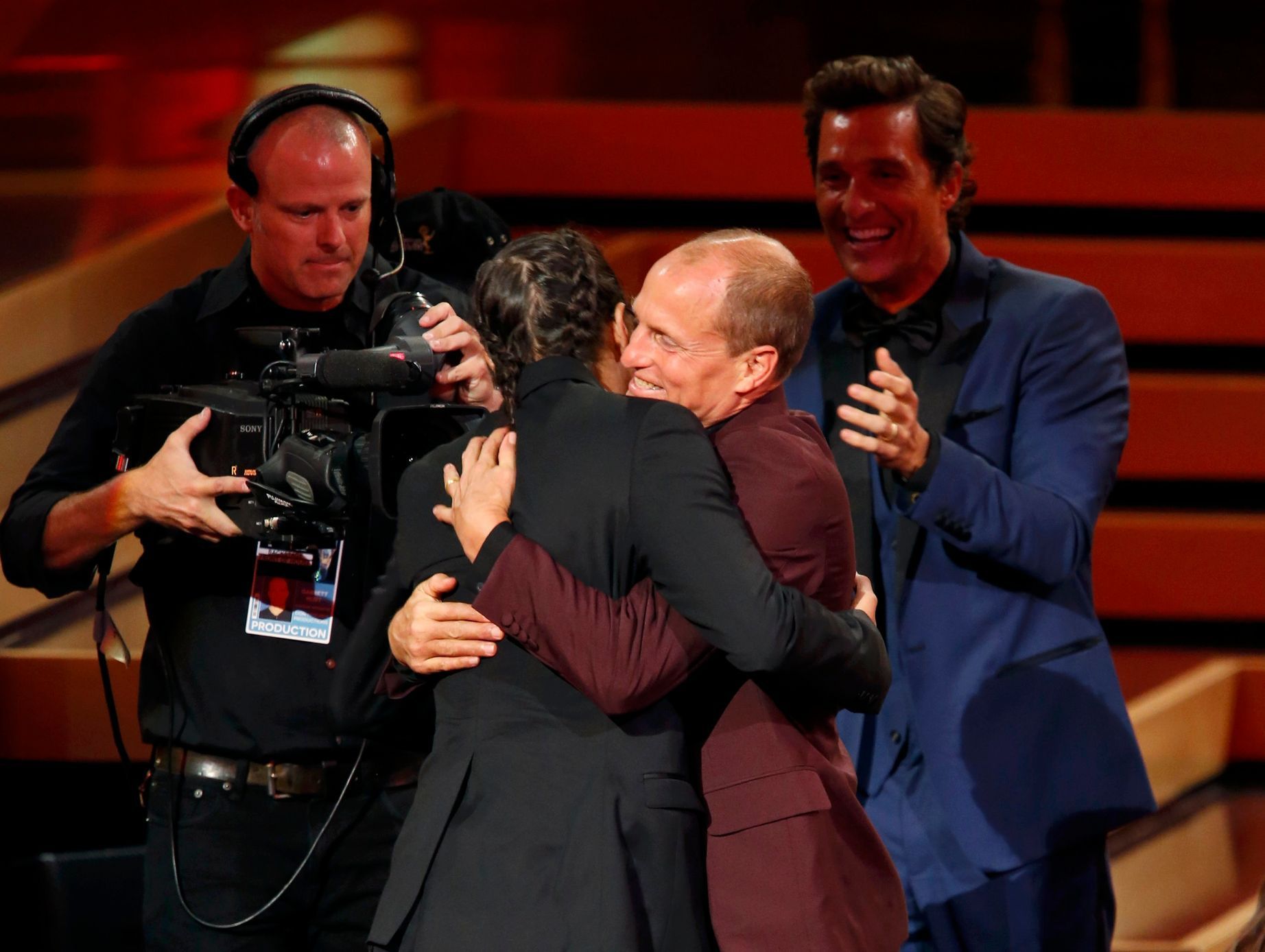 Harrelson hugs director Cary Joji Fukunaga as actor McConaughey applauds as Fukunaga takes the stage to accept the award for Outstanding Directing For A Drama Series for HBO's &quot;True Detective&quo