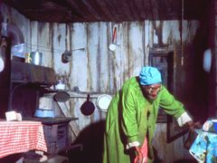 Poor does not mean untidy. An old woman is sweeping her shack with extreme care