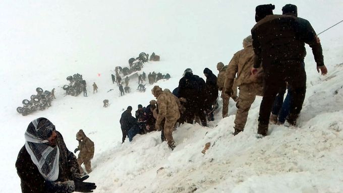 Turečtí vojáci a místní se snaží pomoci lidem zavaleným lavinou.
