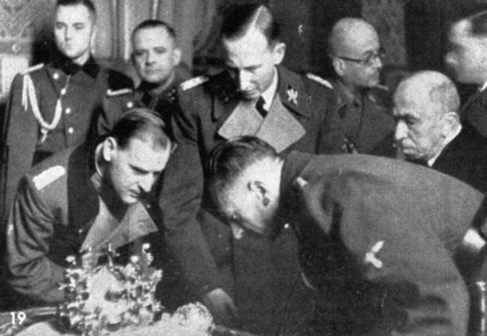 Reinhard Heydrich (uprostřed) si prohlíží české korunovační klenoty. Skloněný vlevo Rudolf Toussaint. Vpravo K. H. Frank. Za ním je státní prezident Emil Hácha.