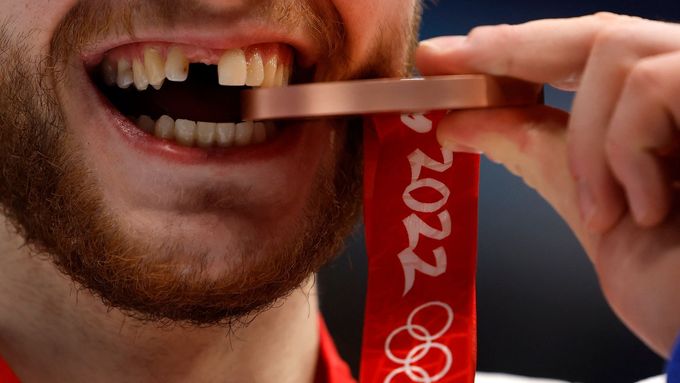 Miloš Roman zkouší tvrdost bronzové olympijské medaile