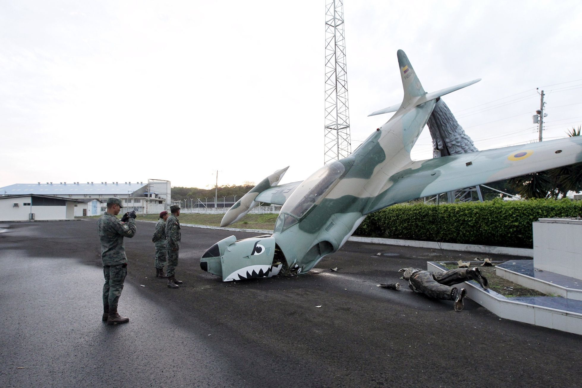Military officers stand next to a damaged sculpture after an earthquake struck off Ecuador's Pacific coast, at the Eloy Alfaro airport in Manta