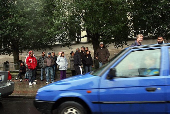 V Trmicích, městečku u Ústí nad Labem, posedávají před volební místností skupinky voličů. Čekají, co se bude dít.