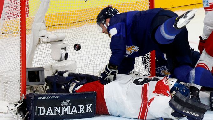 Finský hokejista Iiro Pakarinen se pokouší dostat puk za dánského brankáře Mathiase Seldrupa