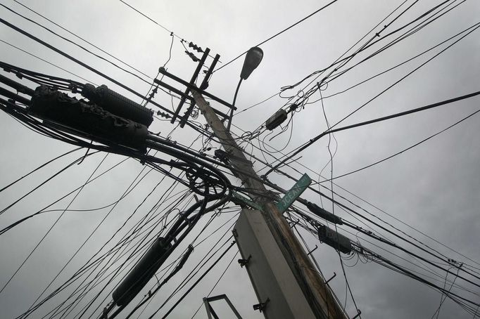 Power lines devastated by fire and the effects of Hurricane Sandy are seen in the Breezy Point section of the Queens borough of New York October 30, 2012. Millions of people across the eastern United States awoke on Tuesday to scenes of destruction wrought by monster storm Sandy, which knocked out power to huge swathes of the nation's most densely populated region, swamped New York's subway system and submerged streets in Manhattan's financial district. REUTERS/Shannon Stapleton (UNITED STATES - Tags: ENVIRONMENT DISASTER) Published: Říj. 30, 2012, 7:58 odp.