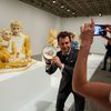 A man holds a signed plate before the opening of a Jeff Koons retrospective at the Whitney Museum of American Art in New York