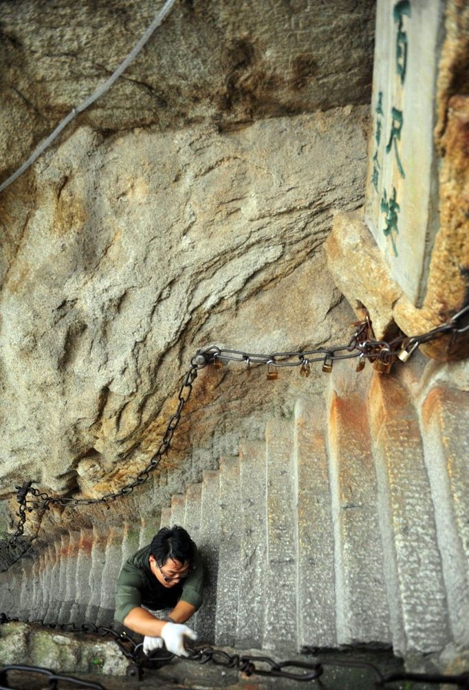 HUAYIN, CHINA - AUGUST 13: (CHINA OUT) Legless man Chen Zhou climbs the Huashan Mountain on August 13, 2012 in Huayin, Shaanxi Province of China. Legless 29-year-old man Chen Zhou from Cangshan of Shandong Province spent two days, 19 hours in total, climbing by arms to the top of Huashan Mountain. Chen lost his legs after falling off a train at the age of 13, but he has since strived to be stronger and joined in many public performances to encourage other people. Chen Zhou will climb the Taishan Mountain in Shandong province in the following months. ( automatický překlad do češtiny )